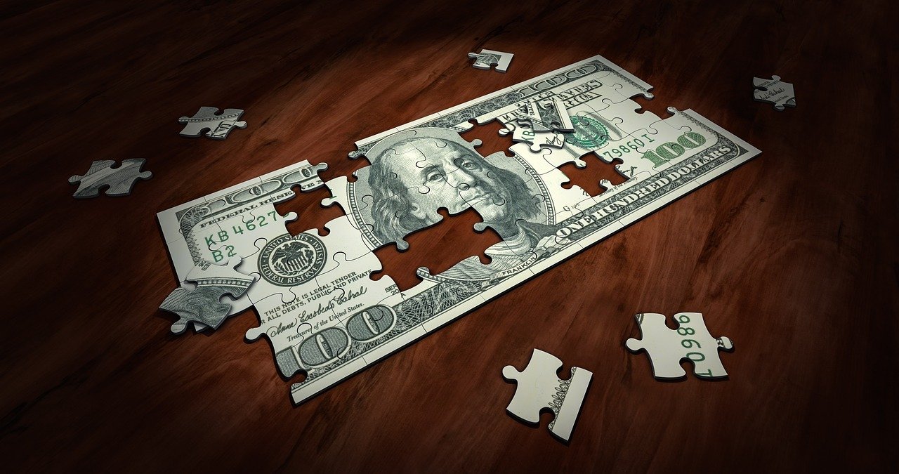 $100 bill pulled apart as a puzzle piece, an image accompanying information about the Consolidated Appropriations Act.